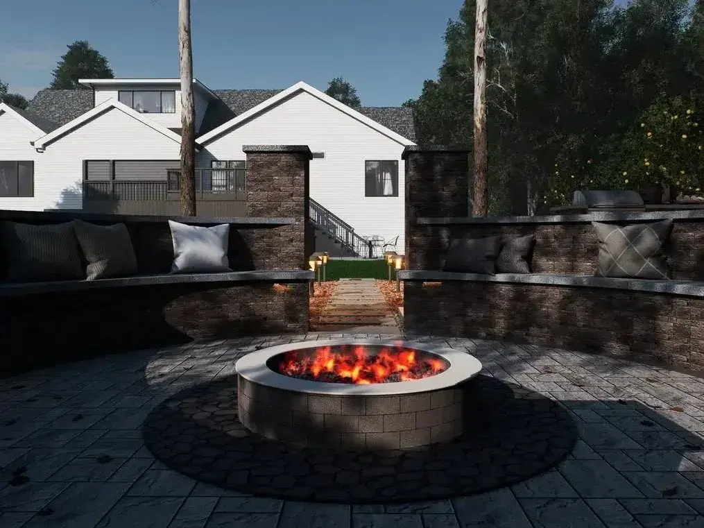 Round fire pit centered in a paver patio surrounded by stone seat walls
