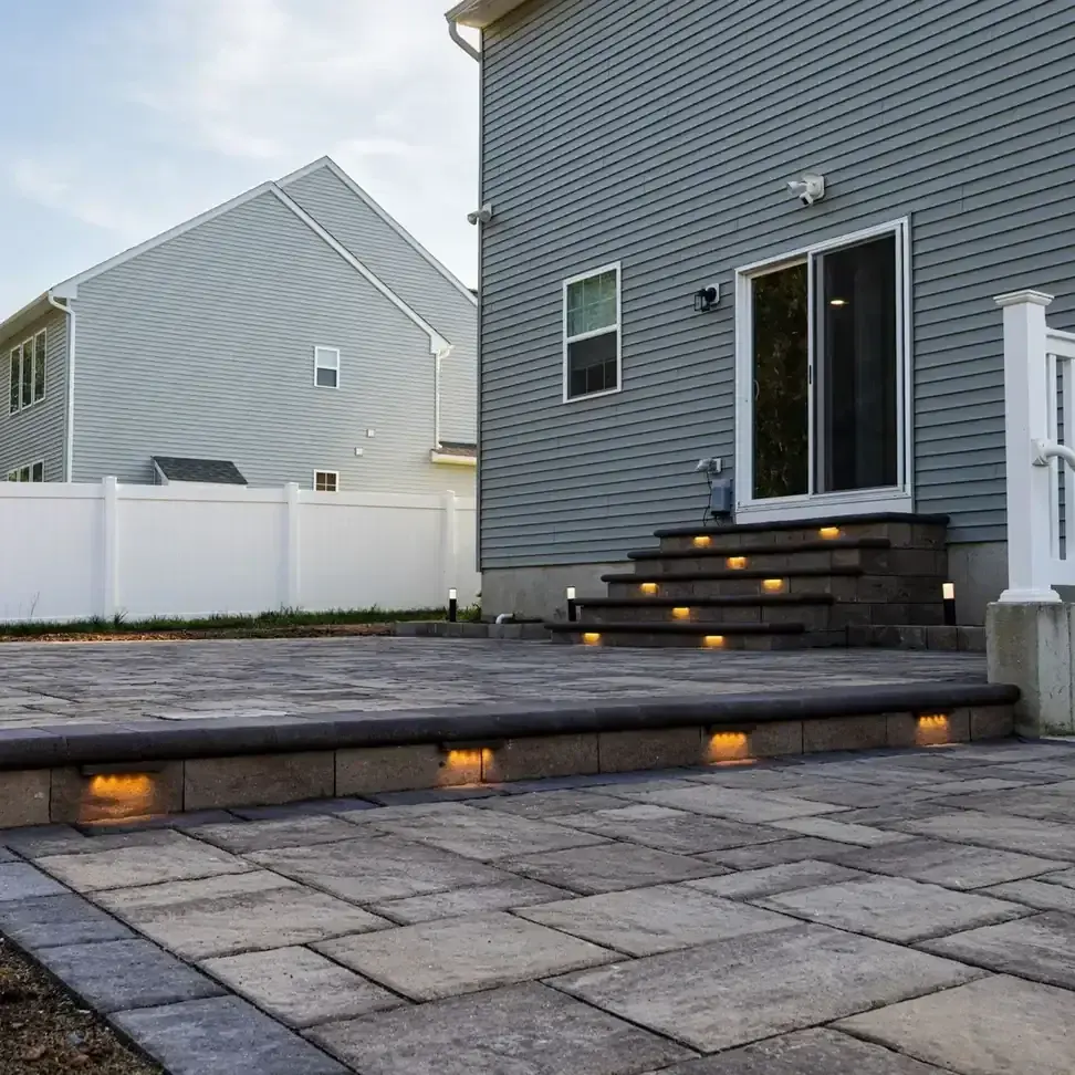 Patio and steps with low-voltage step lighting at the back of a home